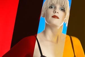 blondes Dessous-Modell zwischen rotenm, blauen und gelben Plexiglasscheiben