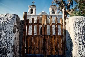 weiße Kirche mit zwei Türmen hinter Holztor