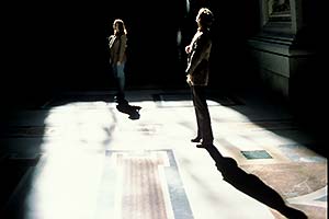 Frau steht im Lichtstrahl in einer Kirche