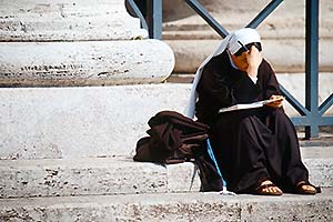 lesende Nonne sitzt auf Säulensockel