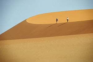 Menschen wandern auf Dünenrand in der Namib